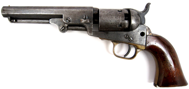 Close-up image of a revolver showing the details of its metal barrel, trigger, and wooden handle.